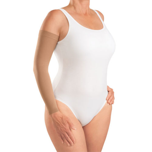 woman wearing white one piece bodysuit with nude arm compression sleeve